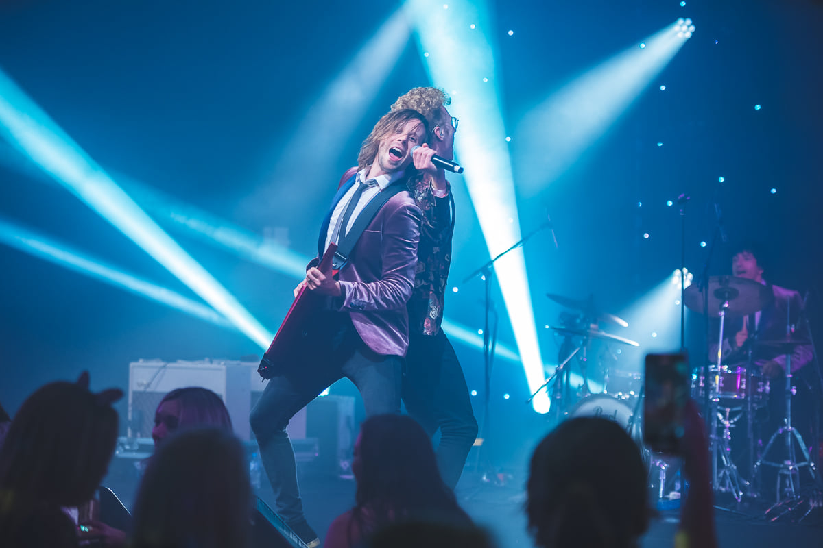 2 men singing on stage