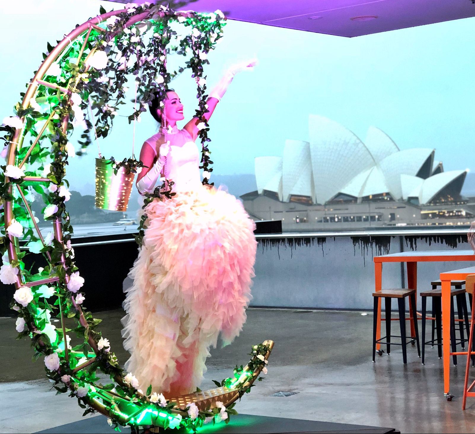 lady dressed on a half moon with LED lights