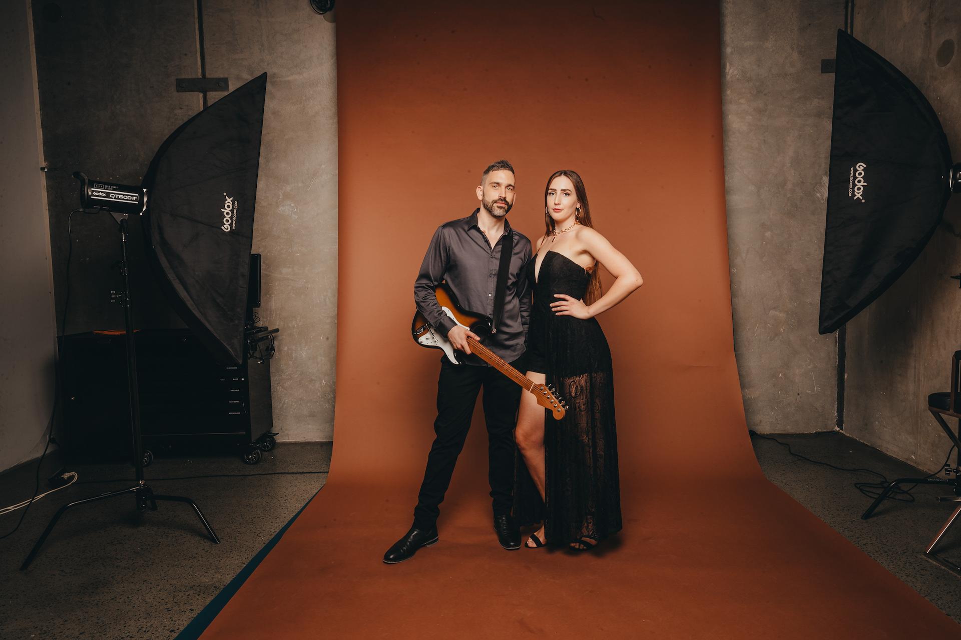 Two music artists. 1 man with a guitar and 1 woman.