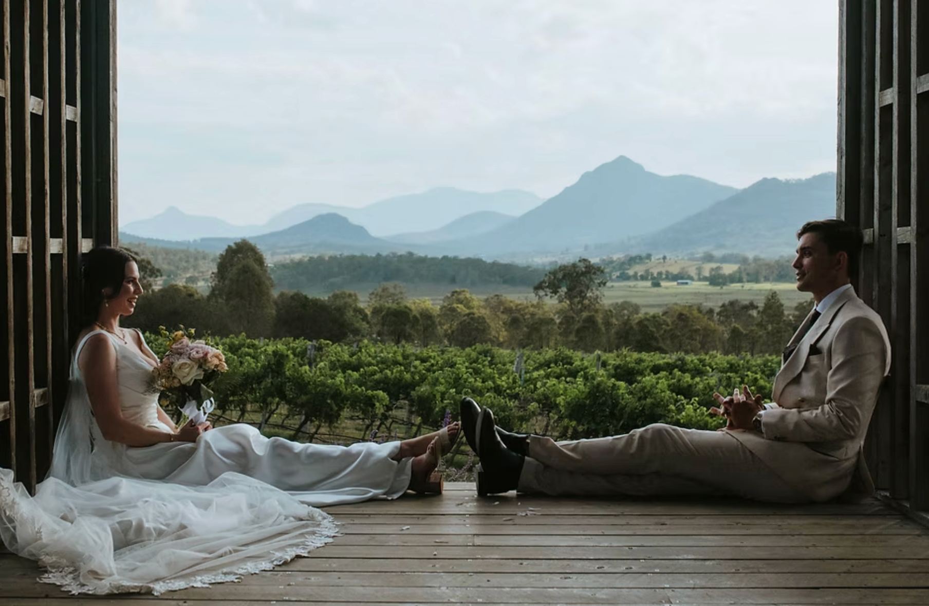 Wedding couple at Kooroomba Vineyard and Lavender Farm with Scenic Rim vineyard and mountain views.