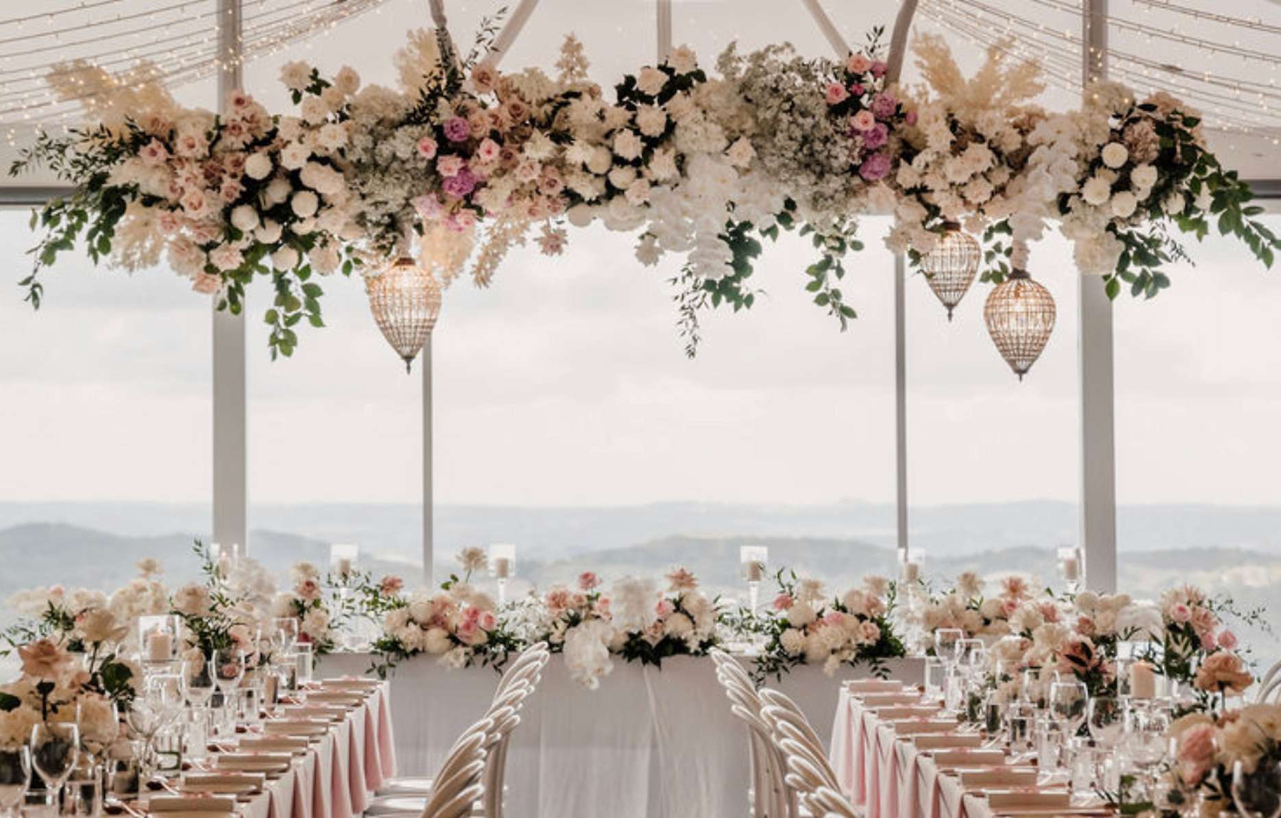 Elegant Mount Lofty House wedding reception with hanging flowers, long tables and mountain views.