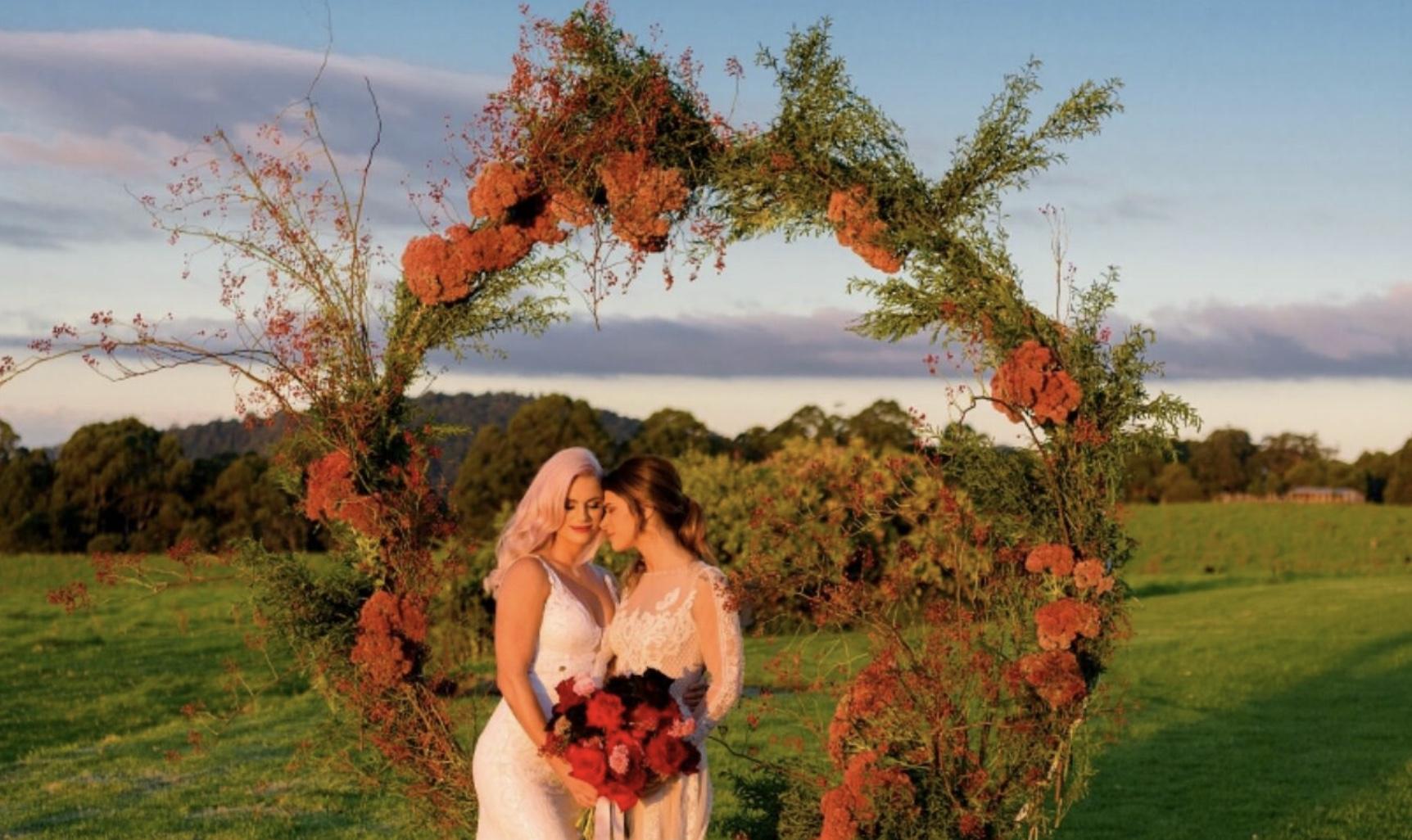 Image Of Two Brides In Beautiful Floral Arbour Country Background Setting 