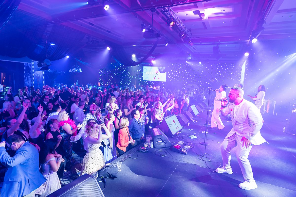 Wedding-Entertainment-Ideas Live band entertaining guests on a packed wedding reception dance floor with stage lighting.