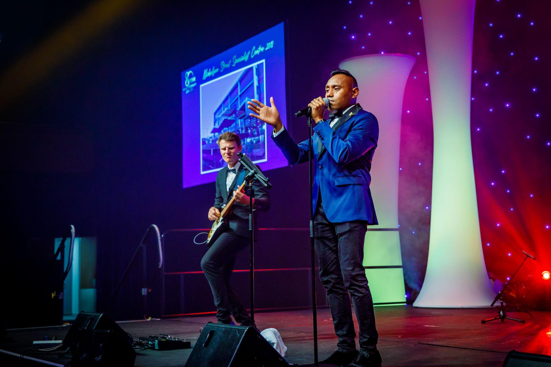 Live band performing on stage at a corporate gala dinner and awards event.