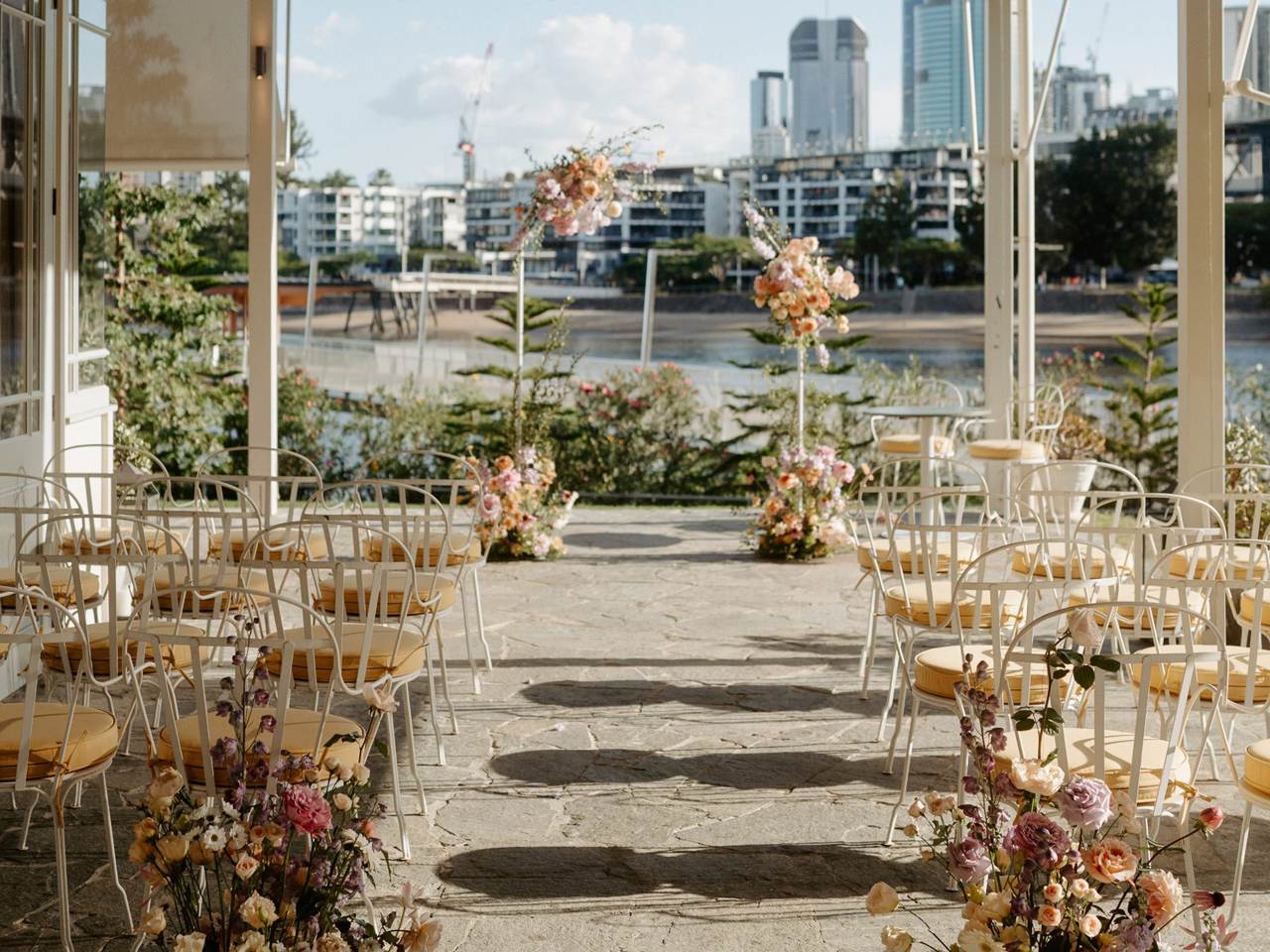 Wedding ceremony setup at Howard Smith Wharves with floral aisle styling, Brisbane River views and the Brisbane city skyline.