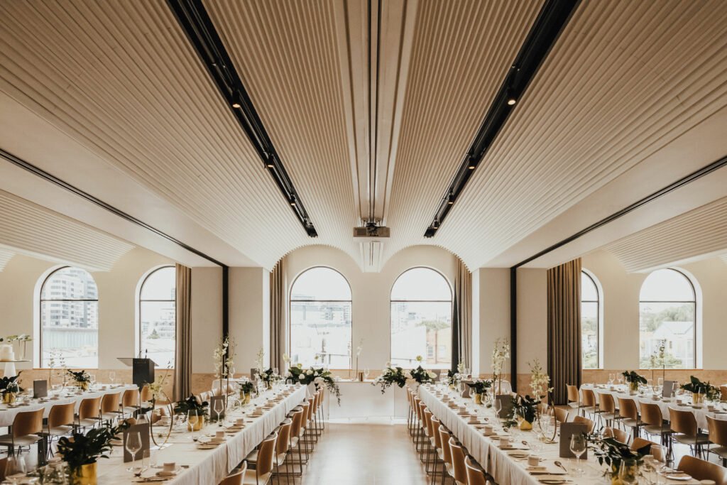 Wedding reception at The Calile Hotel Brisbane with long banquet tables, modern interiors and arched windows.