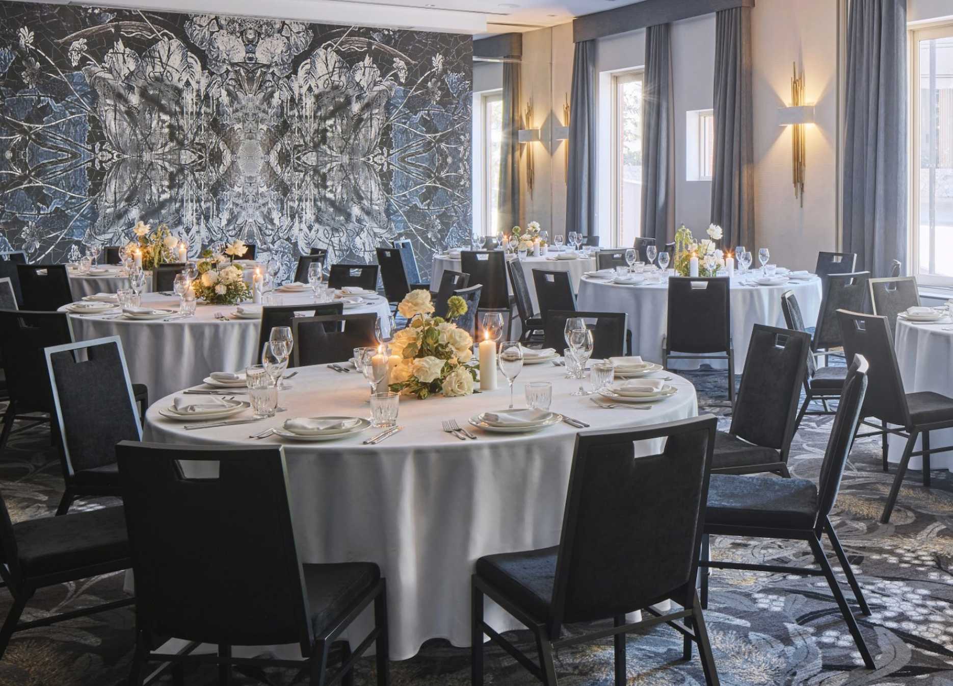 Wedding reception setup in the Charleston Room at The Inchcolm Brisbane with round tables, candlelit florals and boutique hotel interiors.