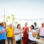 A group of people at an outdoor rooftop party in the Summer in Australia.
