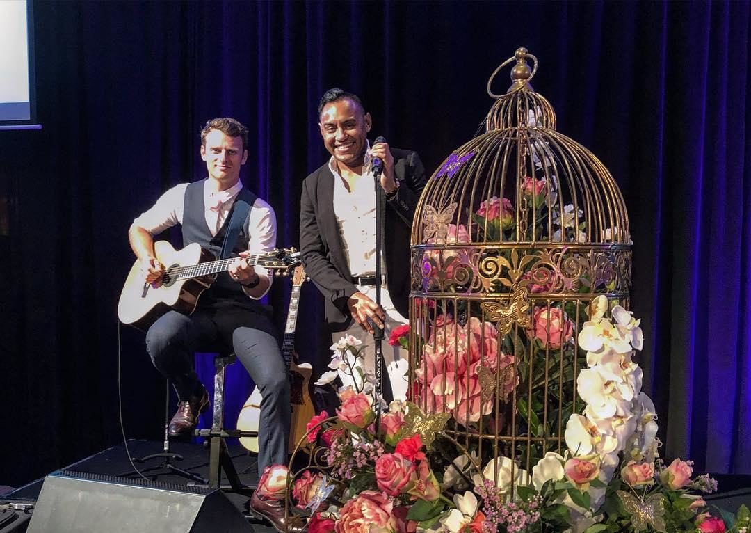 2 male performers on stage at a wedding.