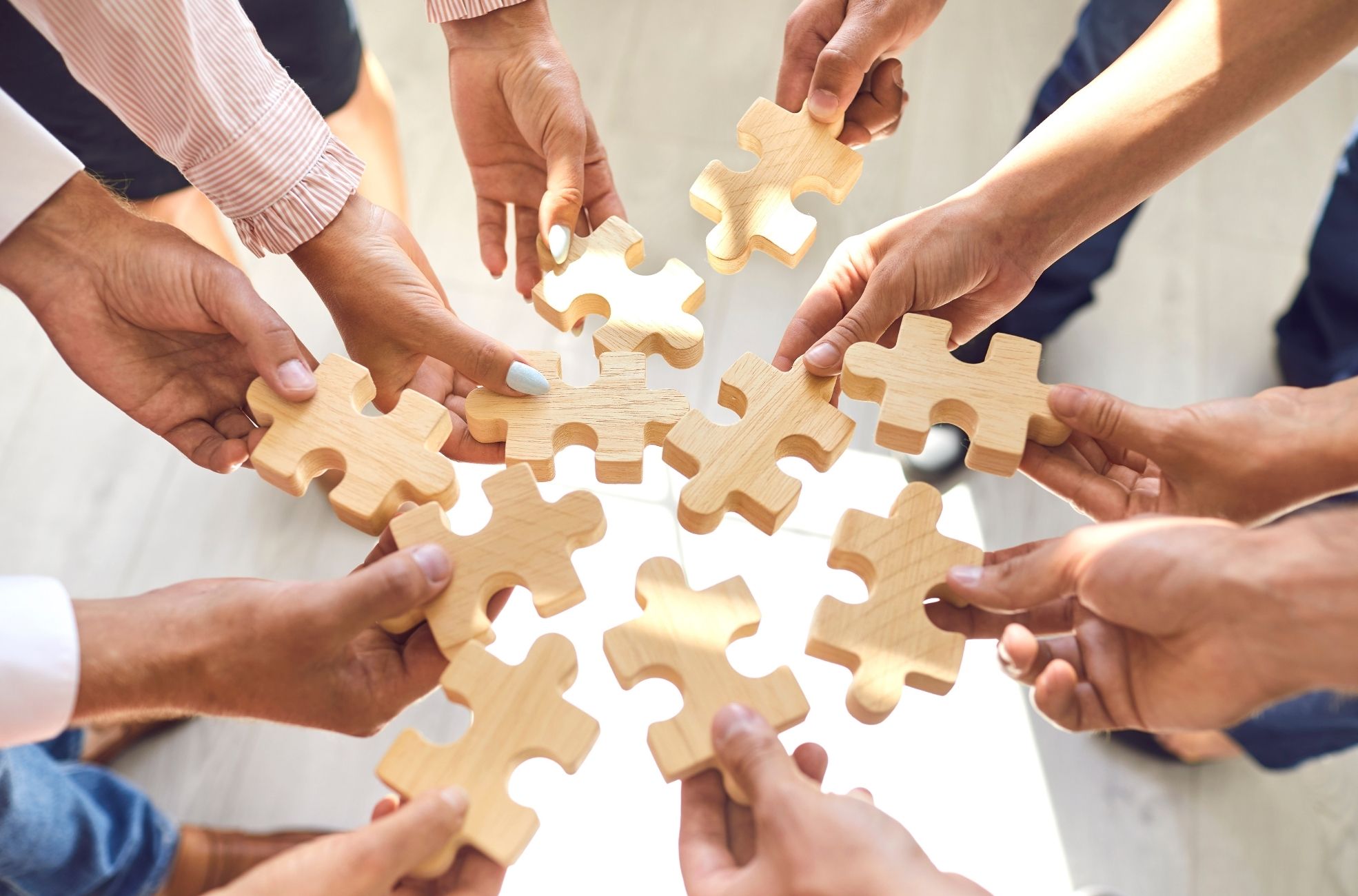 Work Team Holding Wooden Puzzle Pieces