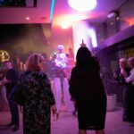 LED roving performer entertaining guests at a corporate party with colourful lighting and aerial entertainment.
