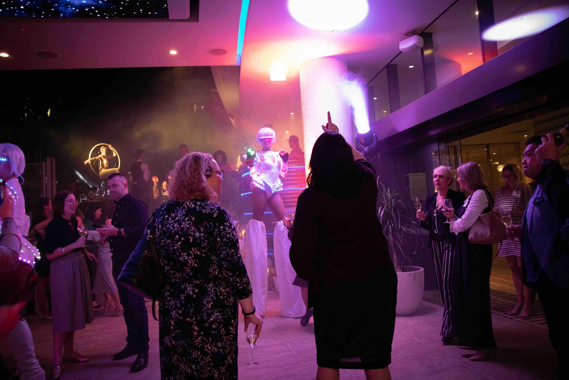 Corporate-Party-Entertainment-Ideas-1 LED roving performer entertaining guests at a corporate party with colourful lighting and aerial entertainment.