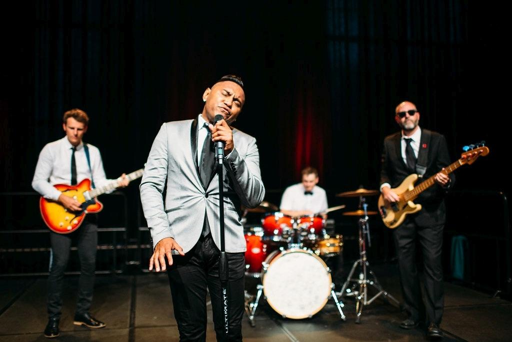 Four-piece live wedding band performing with a lead singer, guitarist, drummer and bass guitarist.