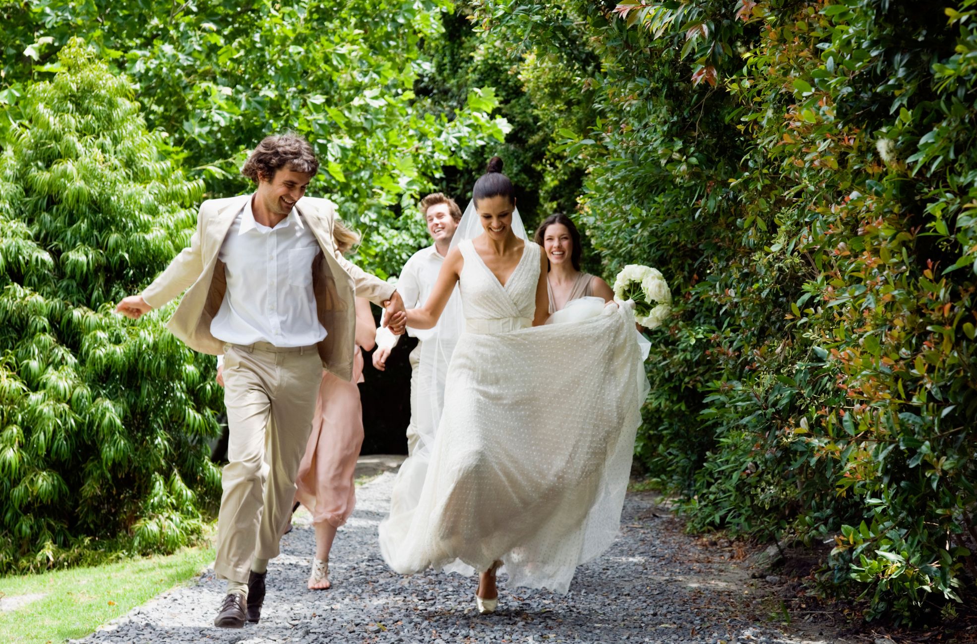 Wedding Party Running In Garden