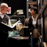 Stage management team reviewing event plans backstage before a live production.