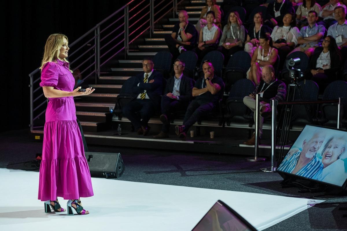 Female keynote speaker presenting to an audience at a corporate conference in Australia.
