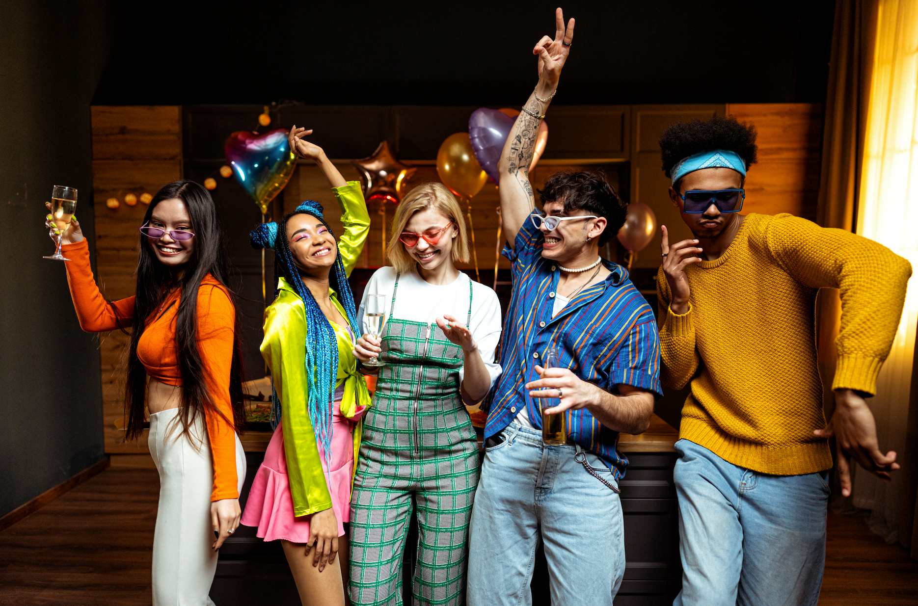 Guests in colourful retro outfits dancing at an 80s themed house party.