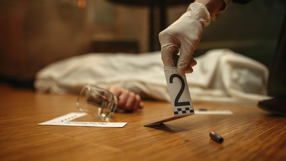 Close up of a detectives hand looking at a clue number at a murder mystery corporate event