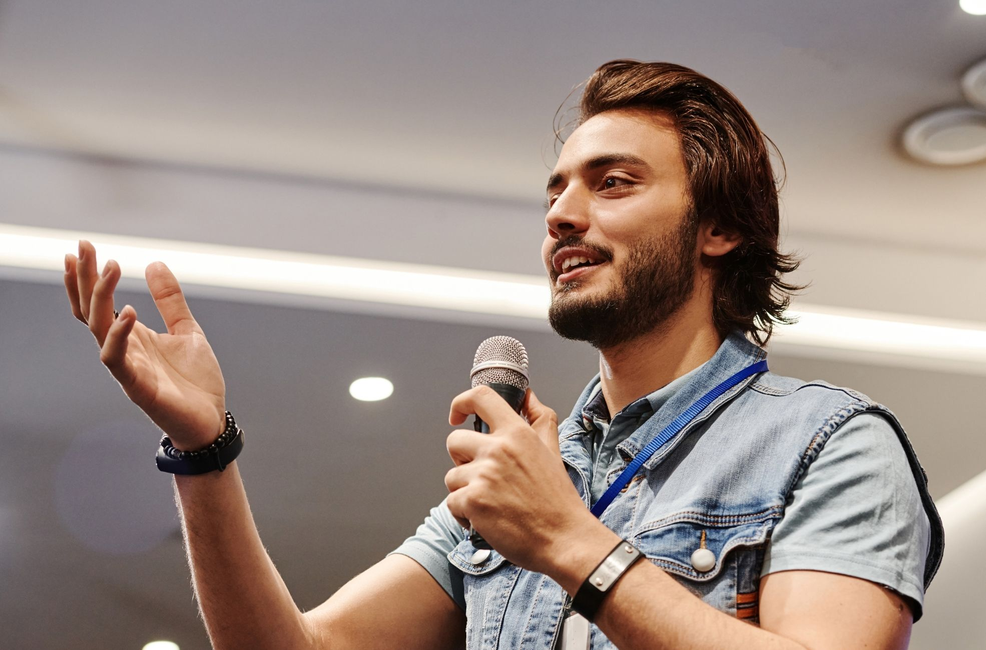 Guest speaker presenting with a handheld microphone at a corporate event.