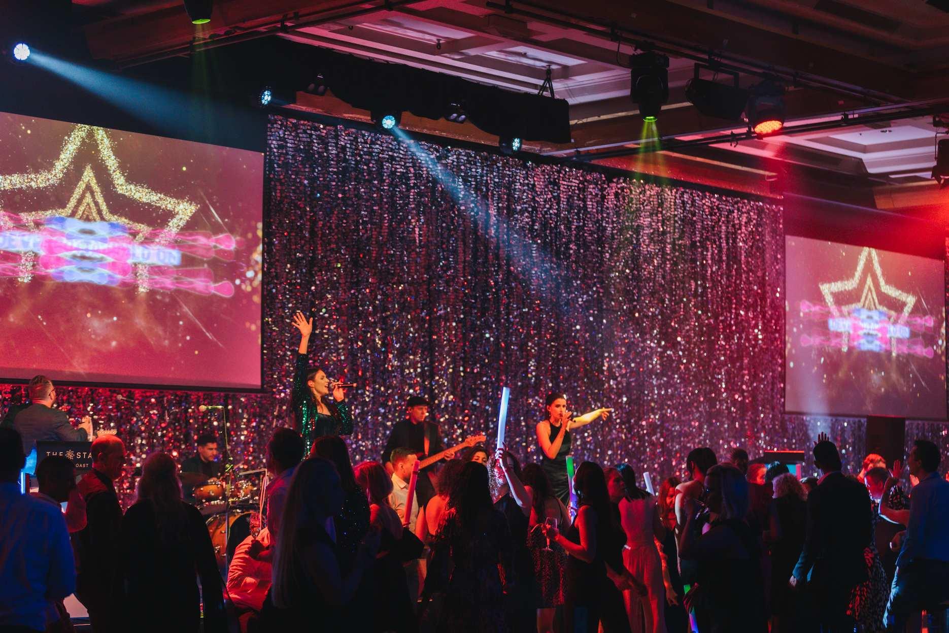how-to-book-corporate-entertainment Live band performing for guests at a corporate event.