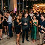 Group of friends enjoying cocktails at a backyard 21st birthday party, socialising and celebrating together.