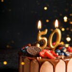 50th birthday cake with gold number candles and elegant celebration styling.