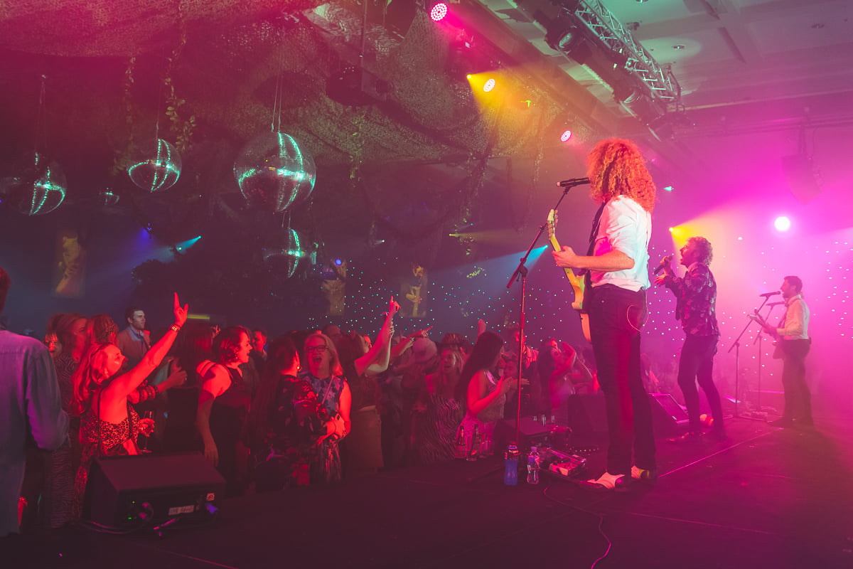 Live band entertaining guests on the dance floor at an 80s party.