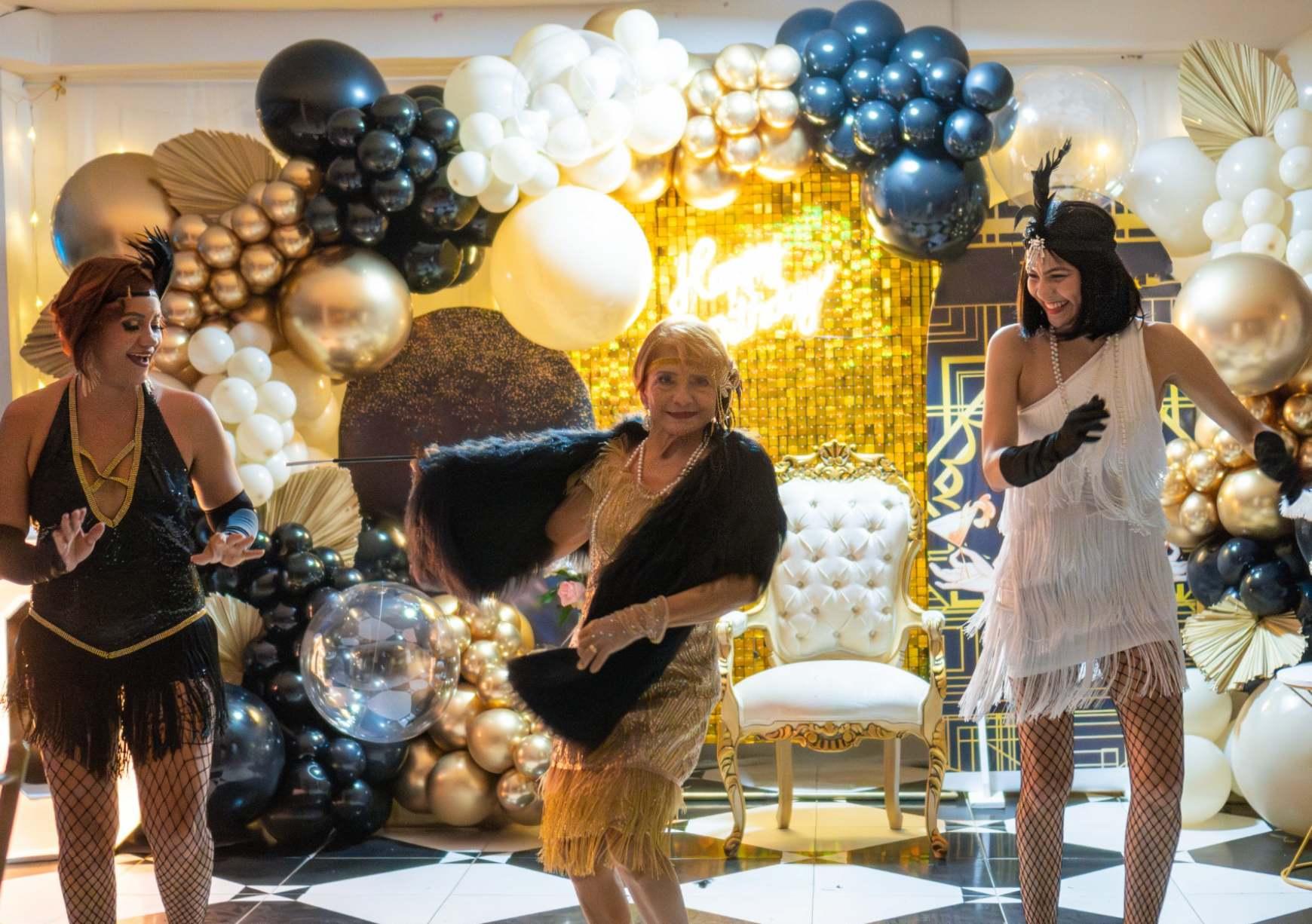 Black and gold themed milestone birthday party with live entertainment performers.