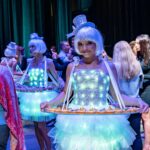 Roving entertainers serving canapés at a 40th birthday cocktail party with colourful event lighting.