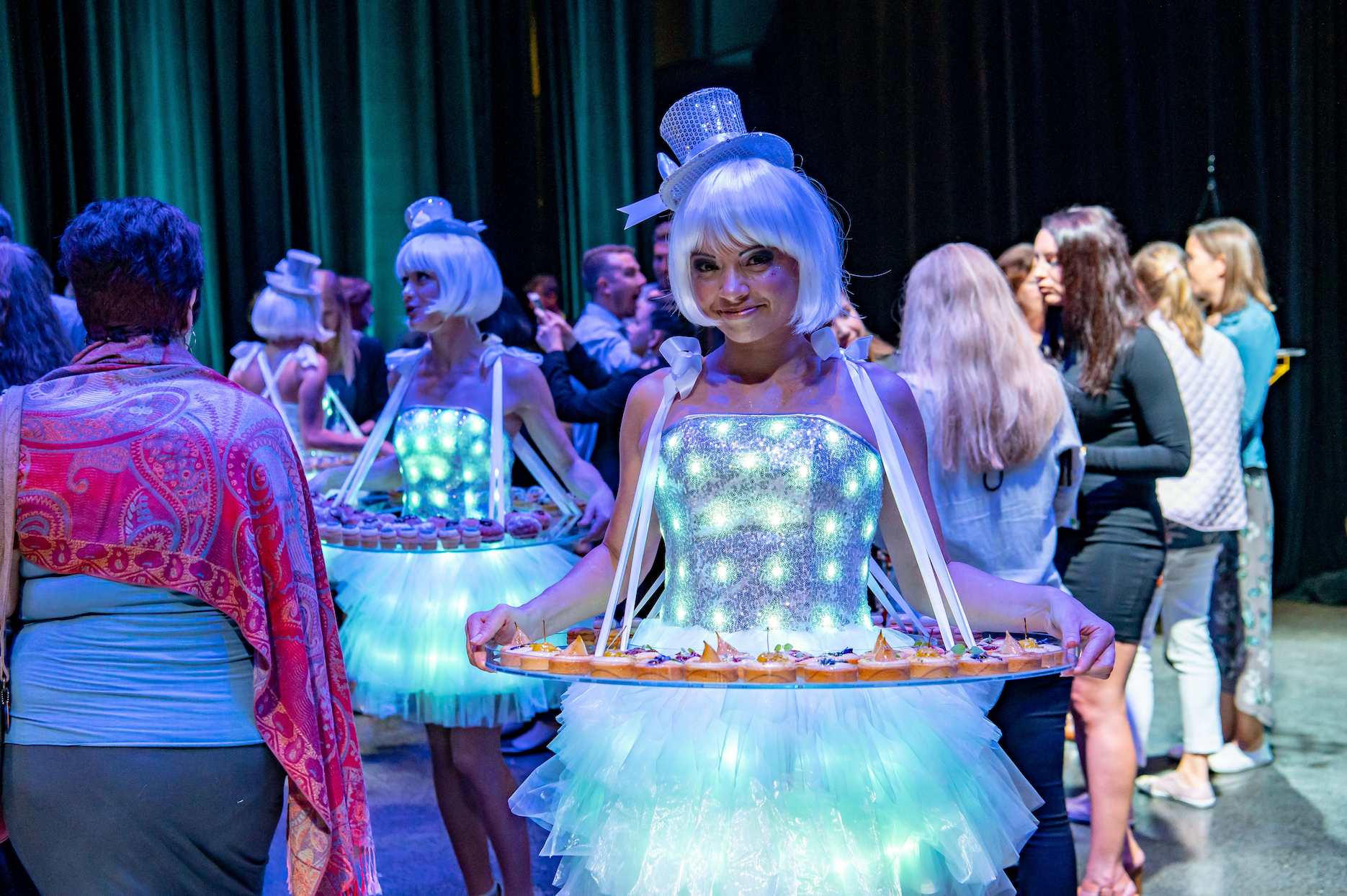 40th-birthday-ideas Roving entertainers serving canapés at a 40th birthday cocktail party with colourful event lighting.