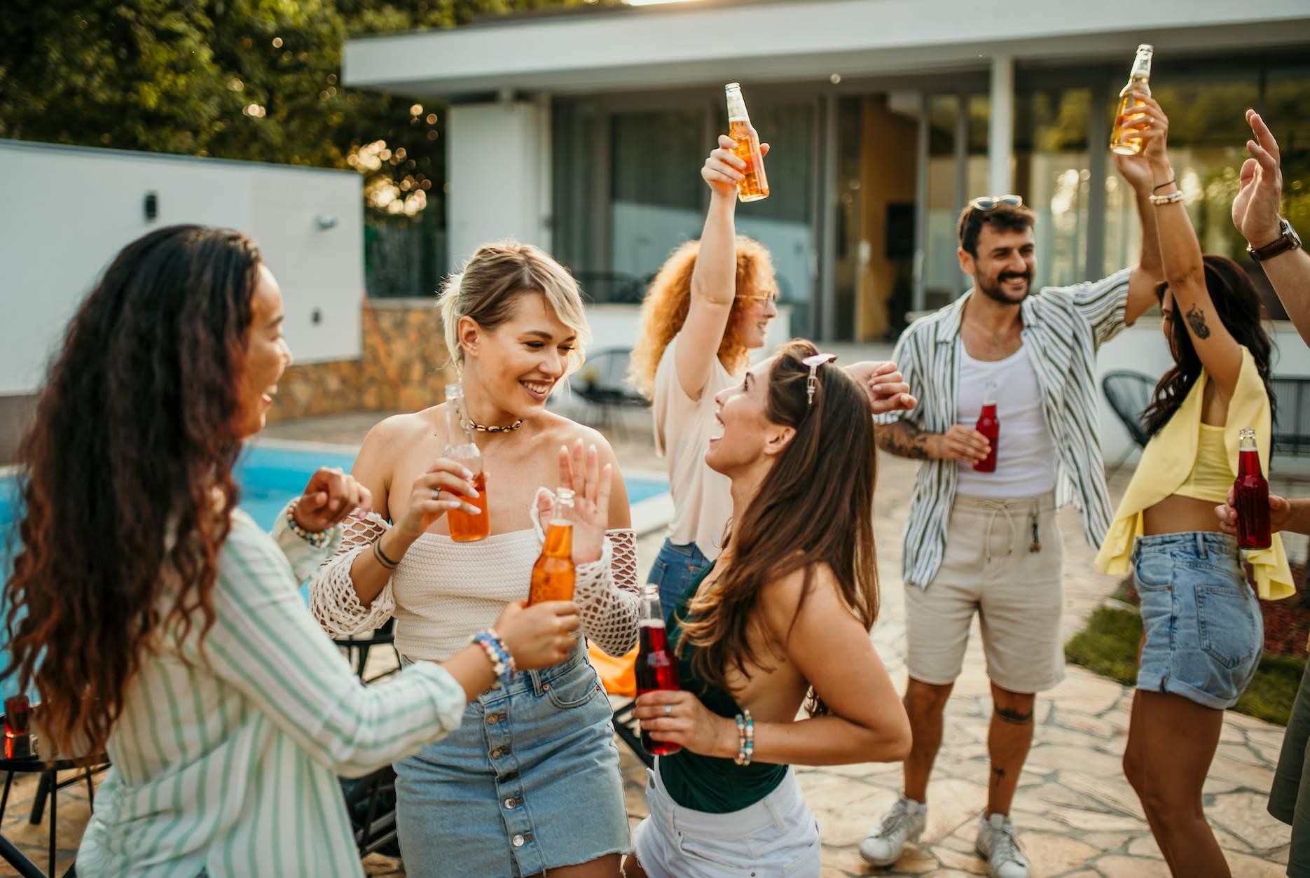 Guests dancing and enjoying drinks at an outdoor birthday party.