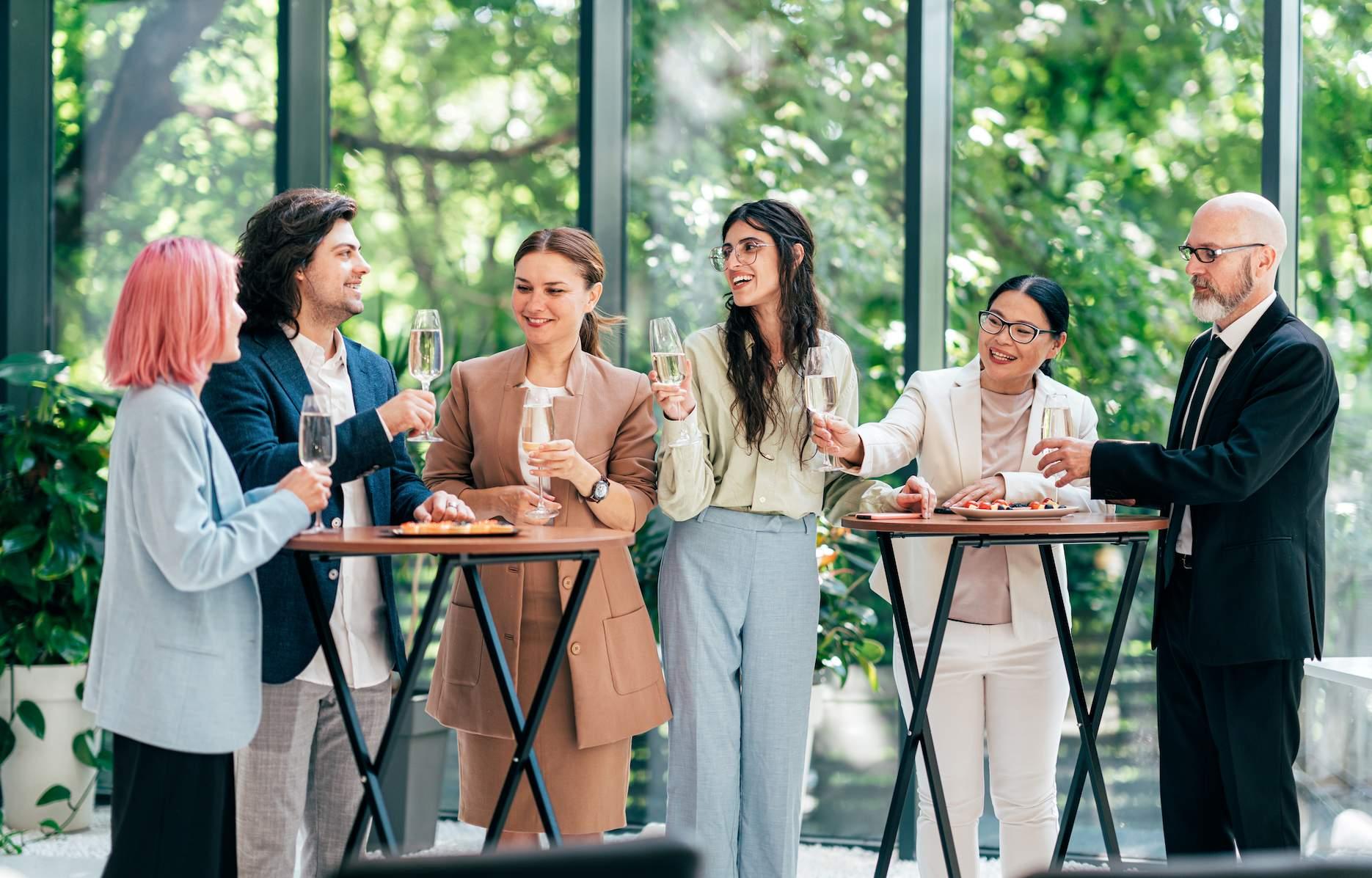 Corporate team enjoying drinks at a relaxed staff party in a garden-style venue.