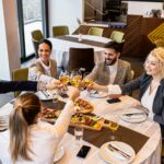 Client appreciation dinner with business professionals raising glasses at a restaurant.